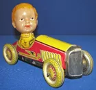 PRE WAR JAPANESE TIN AND CELLULOID BOY IN RACE CAR