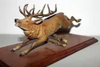 cast metal deer jumping branch