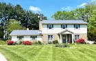 A two (2) story colonial sided house w/ garage