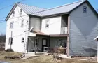 A 2-1/2 story sided house on 4-acres