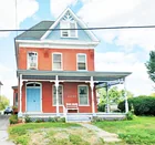 A brick 2-1/2 story house w/ frame garage